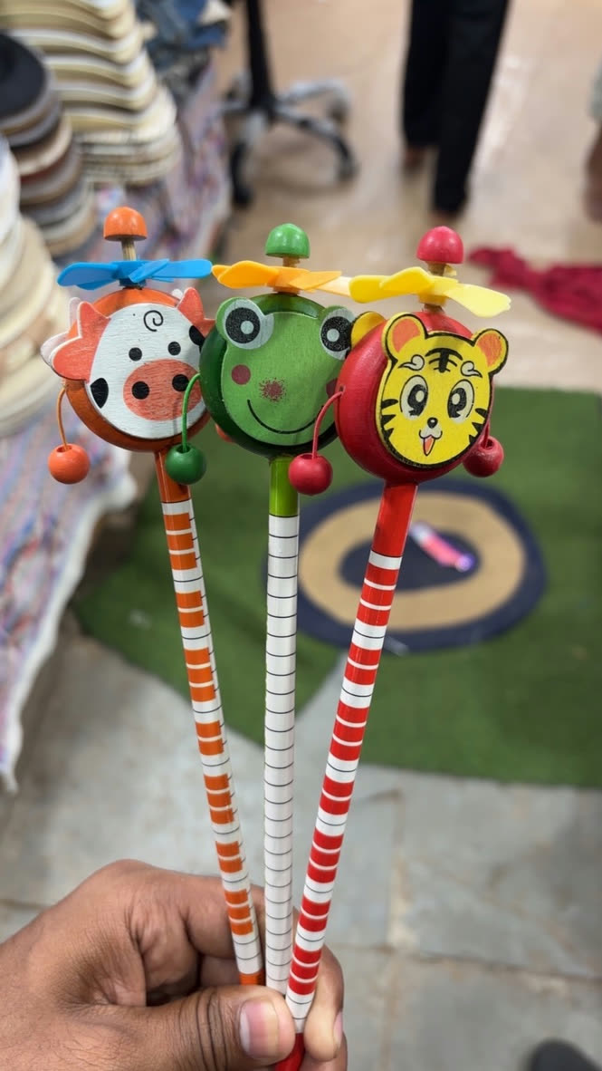Hand holding three animal pencils with tiny propellers
